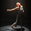 Programme image for "Remote Control". A woman in a printed black and white overall dances under the spotlight. 